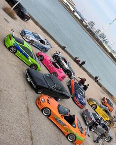 a group of cars parked next to each other in front of a body of water