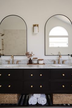 a bathroom with two sinks and mirrors on the wall