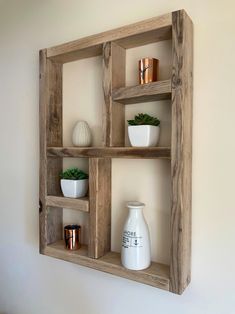 three wooden shelves with pots and vases on them