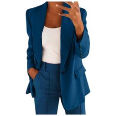 a woman wearing a blue blazer and pants with her hand up to her face