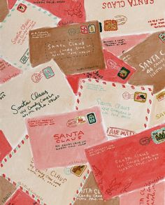 many different colored envelopes are scattered on the table top with red and pink ink