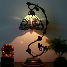 a lamp that is sitting on top of a table next to a potted plant