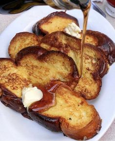 french toast is being drizzled with caramel sauce on a white plate