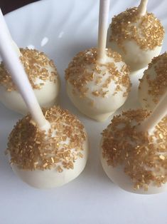 white cake pops with gold sprinkles on a plate