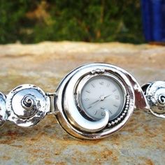 From Porans watches collection: Unique sterling silver watch bracelet for women Inspired by the depth of the sea. Dimensions: Max front Width: 3.5 cm. Min back width: 1 cm. Size: Can be any size you want. Our watch is top quality stainless still, analog, Japanese movement with water resistance (up to 3 atmospheres) and it is powered by a battery that lasts about 3 years. The battery can be exchanged. Please notice that because the watch is made to order the watch mechanism part may look differen Silver Round Analog Watch, Silver Metal Watch As A Gift, Silver Polished Metal Watch, Silver Metal Watches For Anniversary, Silver Polished Finish Watches, Elegant Nickel-free Watches As Gifts, Watch Mechanism, Watches Collection, Watch For Women