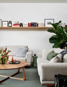 a living room with two couches, a coffee table and some books on the shelves