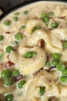 a pot filled with pasta and peas on top of a stove