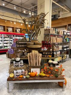 a display in a grocery store filled with lots of food and vegetables on top of a wooden table