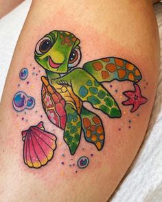 a colorful turtle and sea shells tattoo on the thigh with bubbles around it's legs