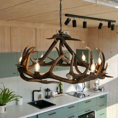 a deer antler chandelier hanging over a kitchen counter