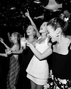 black and white photo of people at a party with confetti in the air