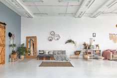 a living room filled with lots of furniture and decor on top of a white floor