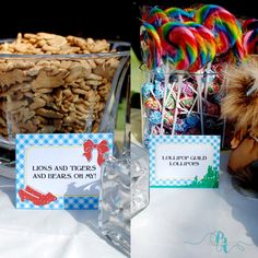 there are candy and candies on display in glass vases at the table with name tags