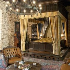 a bedroom with a canopy bed, chair and ottoman in the middle is lit by lights