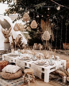 an outdoor table set with place settings and decorations