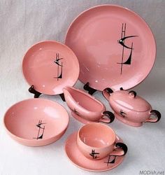 pink dishes and cups with black designs on them