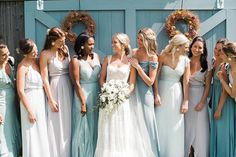 a group of women standing next to each other in front of a blue barn door