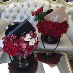 two buckets filled with red and white flowers on top of a table next to a couch