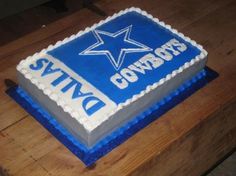 a birthday cake for a cowboys fan on a wooden table with blue and white frosting