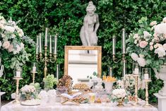 a table topped with lots of white flowers and candles