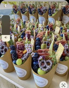 an assortment of fruits in paper cups on a table