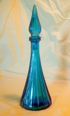 a blue glass vase sitting on top of a table