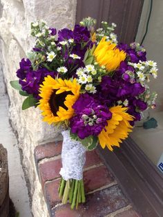 a bouquet of sunflowers and daisies in a vase