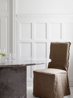 a marble dining table and chair in a white room