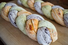 an assortment of pastries sitting on top of a wooden cutting board