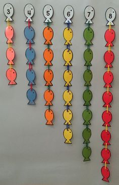 a bunch of different colored fish hanging on the wall