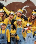 a group of people dressed in minion costumes posing for a photo with their hands up