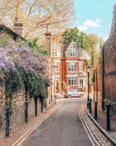 a car is parked on the side of an old brick road in front of a house