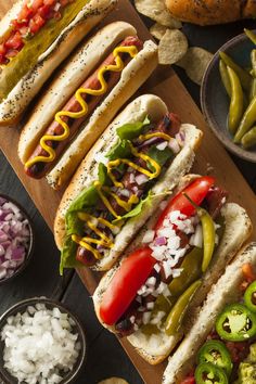 hotdogs with toppings and condiments laid out on a cutting board