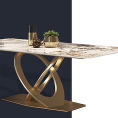 a table with a marble top and gold metal base, in front of a blue wall