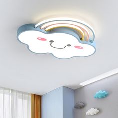 the ceiling light is shaped like a cloud with a rainbow on it's face