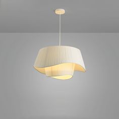 a white lamp hanging from the ceiling in a room with gray walls and flooring