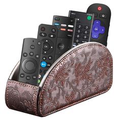 four remote controls in a leather case with floral designs on the front and back sides