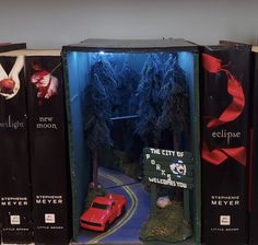 a book shelf with several books on it and a red car in the middle one