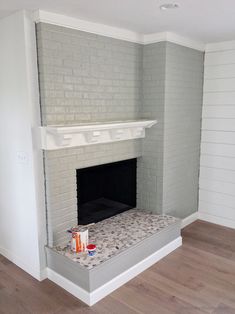 an empty living room with white painted brick fireplace