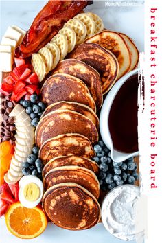 pancakes, fruit, and other foods are arranged on a white platter with text overlay