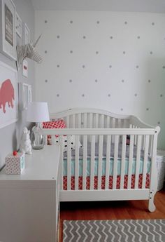 a baby's room with a crib, dresser and pictures on the wall