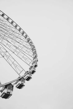 a large ferris wheel is shown against a gray sky