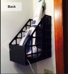 a hair dryer sitting on top of a black shelf next to a door with the words back above it