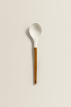 a wooden spoon sitting on top of a white surface