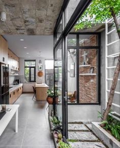 an open kitchen and dining area with wooden cabinets, white counter tops and black glass doors