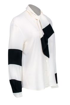 Go classic and chic with this neutral blouse by Louis Feraud! A silk blend button front boluses with color blocked sleeve details featuring black stripes. Pair with your wide leg black pants, a sleek sling back heel, and a colorful leather tote for a posh and polished everyday look! Size 4 60% Acetate, 40% Silk Button front Unlined V-neckline Long sleeve Color blocked design Tie at neckline Bust 40" Waist 40" Shoulder to hem 26" Sleeve length 24" Neutral Blouse, Wide Leg Black Pants, Louis Feraud, Black Wide Leg Pants, Colored Leather, Sling Back, Sleeve Detail, Black Stripes, Everyday Look