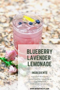 blueberry lavender lemonade in a glass with flowers on the side