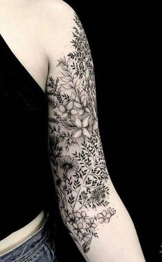 a woman's arm with flowers and leaves on it