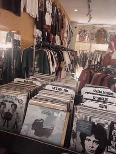 an assortment of records are on display in a record store with elvis presley shirts and other memorabilia