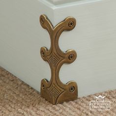 a close up of a door handle on a carpeted floor in front of a white box